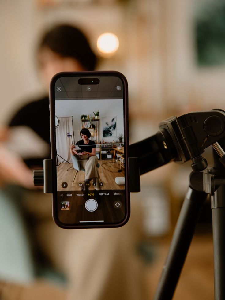Celular en un trípode grabando a una persona en un set